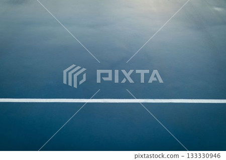 white boundary line stretching horizontally across textured blue sports court in flat design white boundary line stretching horizontally across textured blue sports court in flat design 133330946