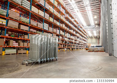 Trolleys and cardboard boxes in warehouse 133330994
