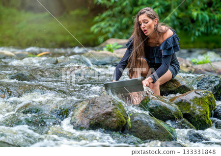 worried woman pulls out of water laptop that fell into river, remote holiday work accident 133331848