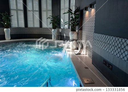 Luxury indoor swimming pool and spa with bubbling blue water Luxury indoor swimming pool and spa with bubbling blue water 133331856