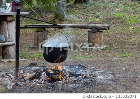 cooking food on a campfire in the woods, place for a bonfire in the rural house 133332071