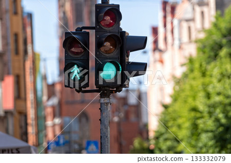 traffic semaphore with green light and green figure of pedestrian on defocused city street 133332079