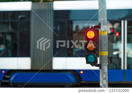 view of city traffic with traffic lights, in the foreground a traffic light with a red light view of city traffic with traffic lights, in the foreground a traffic light with a red light 133332099