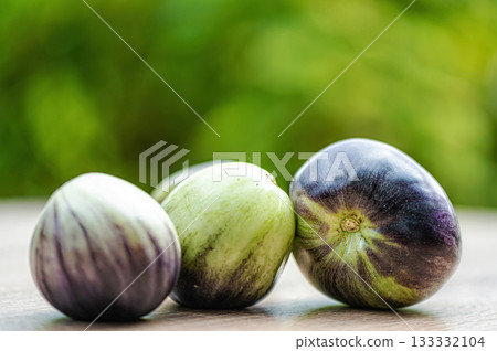 fresh and delicious tomatoes of green-black colored sort on a wooden table, closeup fresh and delicious tomatoes of green-black colored sort on a wooden table, closeup 133332104