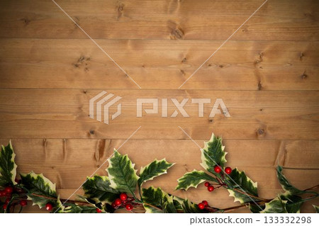 Holly twigs over wooden planks 133332298
