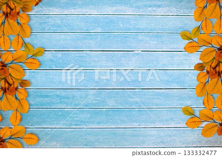 Yellow-orange autumn leaves are framing light blue wooden plank flat design backdrop Yellow-orange autumn leaves are framing light blue wooden plank flat design backdrop 133332477