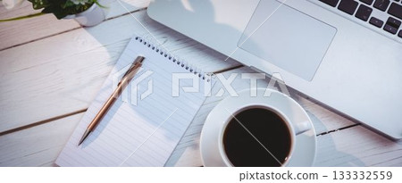 Laptop with book and coffee cup on table 133332559