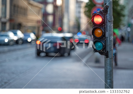 view of city traffic with traffic lights, in the foreground a traffic light with a red light 133332762