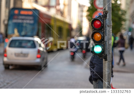 view of city traffic with traffic lights, in the foreground a semaphore with a green light, closeup view of city traffic with traffic lights, in the foreground a semaphore with a green light, closeup 133332763