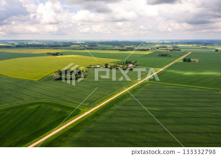 wide countryside before the storm, top view of green agricultural fields and road 133332798