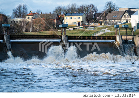 Spring flood water flows over the locks on the Berze river in Dobele, Latvia Spring flood water flows over the locks on the Berze river in Dobele, Latvia 133332814