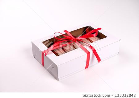 packing box with eclair with glaze and strawberries, isolated on white, closeup 133332848