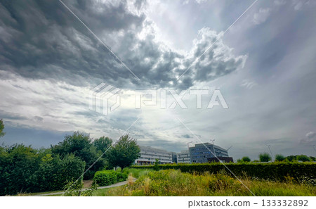 Dark clouds cast shadows on elegant buildings beneath ominous sky Dark clouds cast shadows on elegant buildings beneath ominous sky 133332892