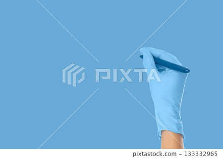 Gloved hand prepares to take notes in a medical setting 133332965