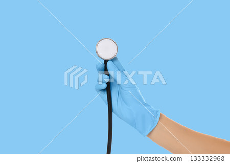Hand grasps a stethoscope while wearing medical gloves Hand grasps a stethoscope while wearing medical gloves 133332968