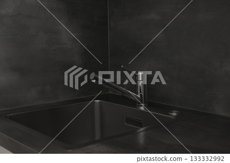 Stylish dark kitchen featuring a metallic faucet and sink 133332992