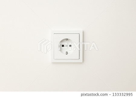 Close up view of a standard electrical outlet on a plain wall 133332995