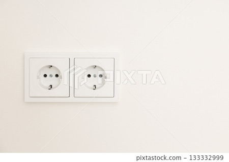Double electrical outlets in a minimalist indoor setting 133332999