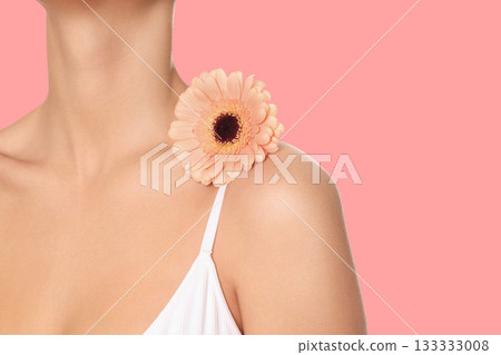 Relaxed woman enjoys body care with a flower 133333008