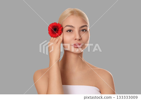 Model showcases skincare with a bright flower accessory 133333009