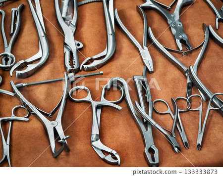 Various surgical instruments arranged on a textured surface depicting an organized display for medical use in a healthcare setting Various surgical instruments arranged on a textured surface depicting an organized display for medical use in a healthcare setting 133333873