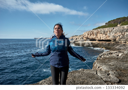 young woman backpacker hiking on the rocky coast young woman backpacker hiking on the rocky coast 133334092