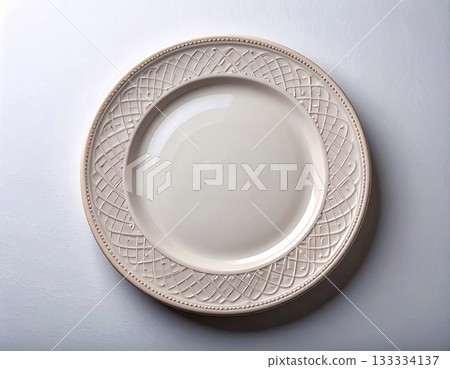 Sophisticated decor. Ceramic plate with a classic white design and floral border on a white background. Porcelain kitchenware. Close-up. Top view. 133334137