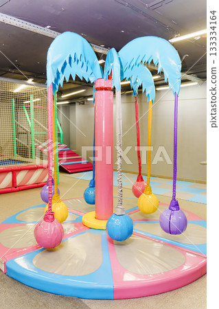 Colorful play area with soft swings and palm tree design 133334164