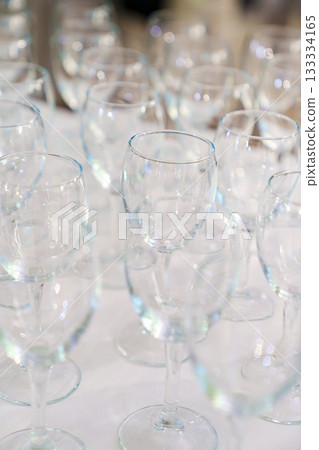 Lots of empty, clean glasses on the table. 133334165