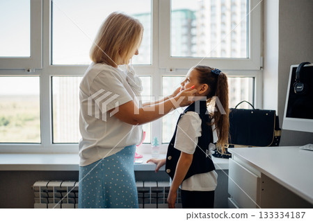 Mother helping daughter get ready in bright modern apartment Mother helping daughter get ready in bright modern apartment 133334187