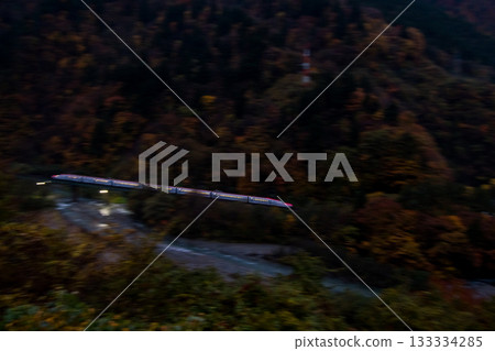 [Akita Shinkansen] Limited Express Komachi passing through a valley at dusk in autumn 133334285