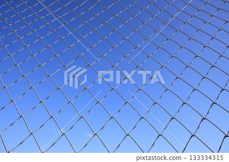 Chainlink fence and blue sky Chainlink fence and blue sky 133334315
