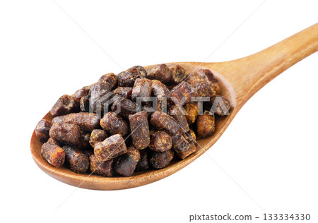 Bee bread in a wooden spoon close-up on a white. Isolated 133334330
