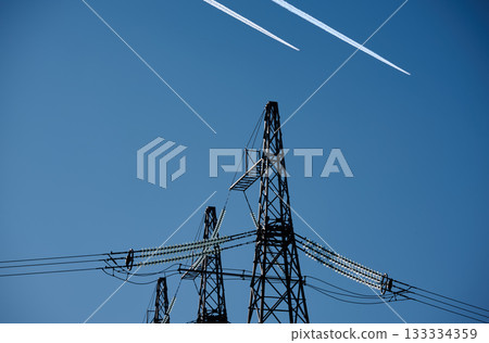 High voltage towers stand tall against the sky. 133334359