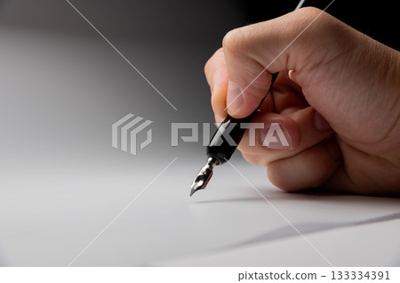 hand writes with a black pen on a clean white background with ample space for text. The hands masterfully practiced calligraphy on textured paper, surrounded by a serene atmosphere 133334391