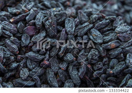 Raisins as a background image. Close-up of raisins, dark-colored dried grapes. Dark blue macro shot of seedless raisins Raisins as a background image. Close-up of raisins, dark-colored dried grapes. Dark blue macro shot of seedless raisins 133334422