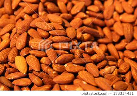 Almonds as a background. Whole brown shelled almonds, piled. Almonds, top view. Flat lay, packaging design element 133334431