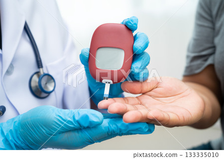 Doctor check diabetes from finger blood sugar level with finger lancet. 133335010