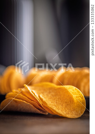 Crispy potato chips on wooden table. 133335862
