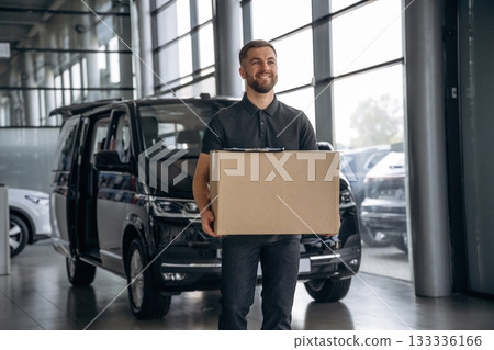 Fast delivery service, standing. Man loader is near the car with a box Fast delivery service, standing. Man loader is near the car with a box 133336166