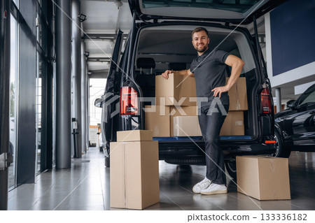 Bunch of boxes. Delivery man or loader is near the car 133336182