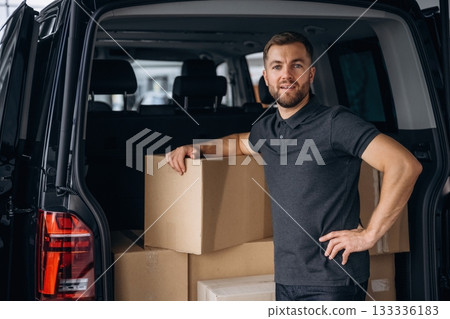 Bunch of boxes. Delivery man or loader is near the car Bunch of boxes. Delivery man or loader is near the car 133336183