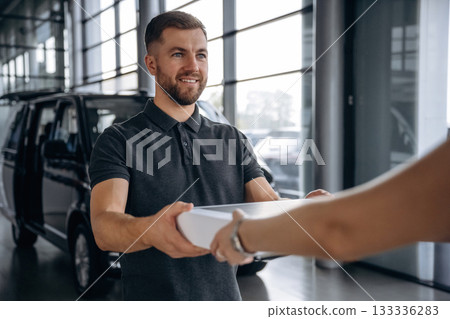 Hands, customer is bought the stuff. Woman is taking her order from delivery man, with the car Hands, customer is bought the stuff. Woman is taking her order from delivery man, with the car 133336283