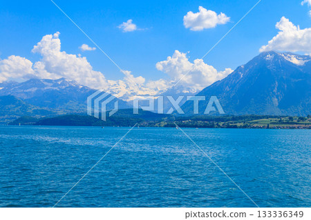 View of the Annecy lake surrounded by beautiful mountains in Annecy, France View of the Annecy lake surrounded by beautiful mountains in Annecy, France 133336349