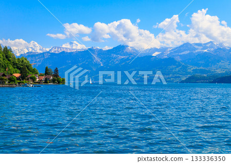 View of the Annecy lake surrounded by beautiful mountains in Annecy, France View of the Annecy lake surrounded by beautiful mountains in Annecy, France 133336350