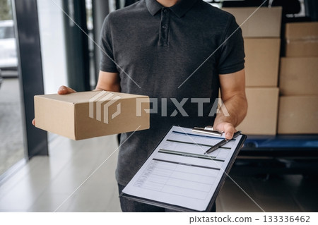 Data in the notepad. Delivery man or loader is near the car with a box Data in the notepad. Delivery man or loader is near the car with a box 133336462