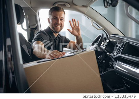 The delivery man or a loader is in the car with box 133336479