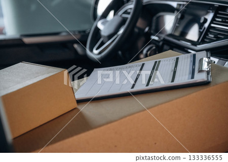 Notepad on boxes in the car, conception of delivery Notepad on boxes in the car, conception of delivery 133336555