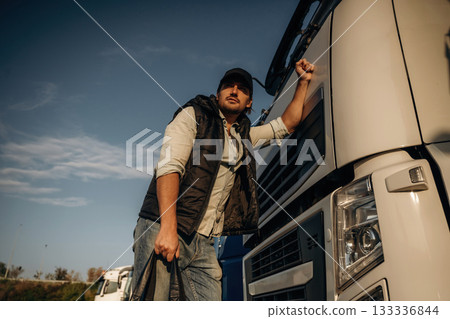 Truck driver is near the transport outdoors Truck driver is near the transport outdoors 133336844