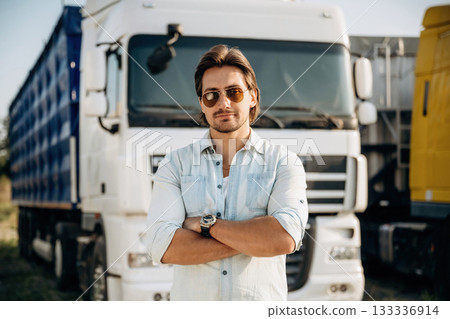 Standing with arms crossed. Truck driver is near the transport outdoors 133336914
